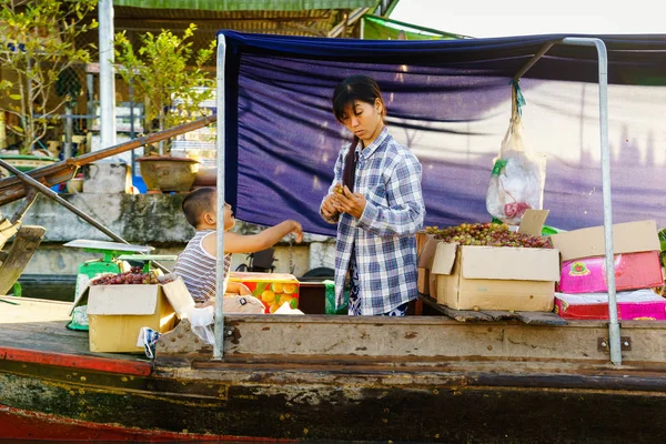 Nga Nam Floating Market, Soc Trang, Vietnam - Nov 22, 2014: La madre y su hijo venden frutas y verduras locales en Nga Nam Floating Market por la mañana temprano. El mercado es el punto convergente de cinco ríos que fluyen en cinco direcciones diferentes — Foto de Stock
