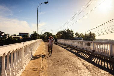 A local woman is on the bridge, Quang Nam, Vietnam. The Quang Nam province has two UNESCO World Heritage Sites. clipart