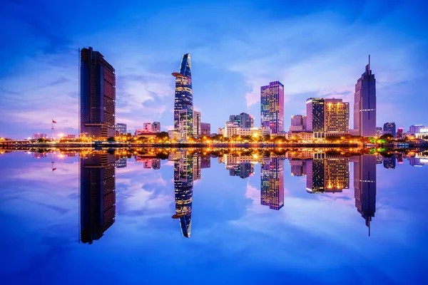 Cityscape in reflection of Ho Chi Minh city at beautiful twilight, viewed over Saigon river. Hochiminh city is the largest city in Vietnam with population around 10 million people — Stock Photo, Image