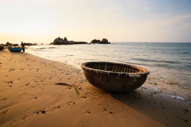 Sabah erken, Binh Thuan, Vietnam Co Thach Plajı'nda bir sepet tekne. Co Thach bin-yıl-taş yeşil yosun kaplı olan fotoğrafçı için yeni bir yer.