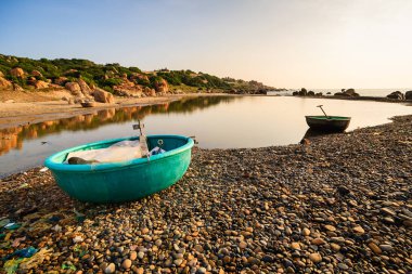 Sabah erken, Binh Thuan, Vietnam Co Thach Plajı'nda bir sepet tekne. Co Thach bin-yıl-taş yeşil yosun kaplı olan fotoğrafçı için yeni bir yer.