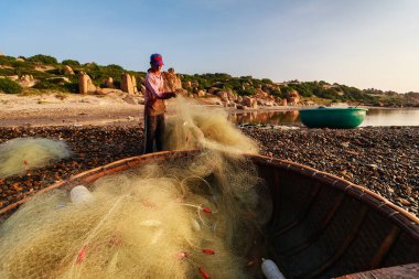 Balıkçılar Co Thach Plajı'nda balık toplamak sabah erkenden Binh Thuan, Vietnam. Co Thach bin-yıl-taş yeşil yosun kaplı olan fotoğrafçı için yeni bir yer.