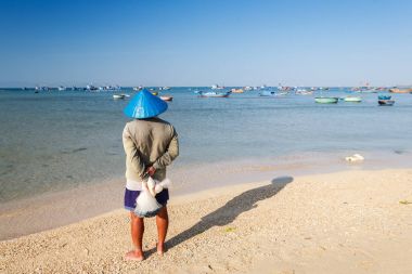 Sabah erken, Ninh Thuan, Vietnam My Hiep plajda mavi koni şapka ile bir balıkçı. Ninh Thuan güzel manzaralar, görkemli Cham kuleleri ve benzersiz Cham kültür için ünlüdür.