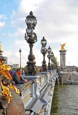 Pont Alexandre III üzerinde duran insanlar