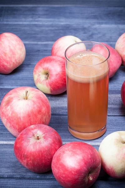 Свежевыжатый яблочный сок в стакане на темном деревянном столе — стоковое фото