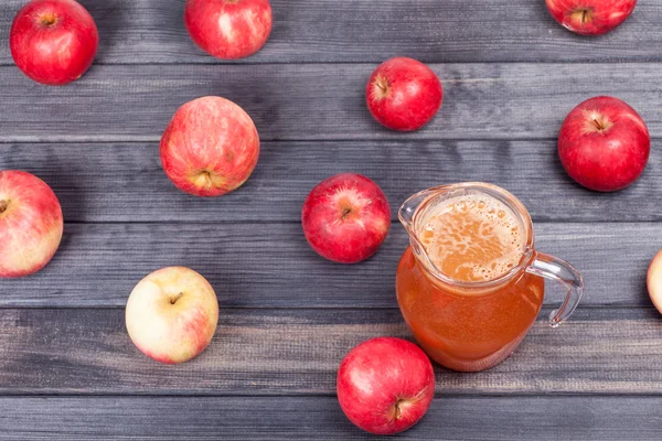 Красные яблоки и сок на деревянном столе вид сзади — стоковое фото