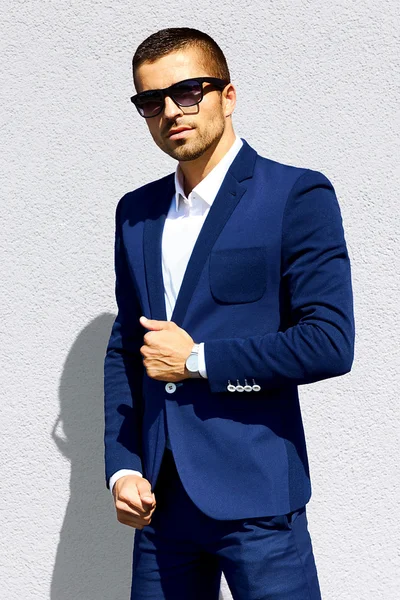 Hombre de traje azul y gafas de sol de pie —  Fotos de Stock