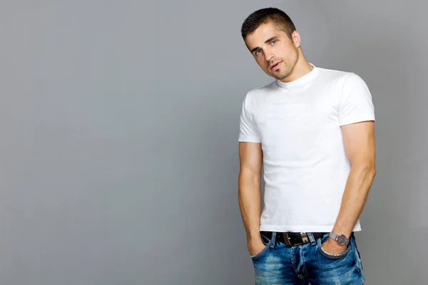 Yakışıklı adam beyaz bir T-shirt ve kot pantolon — Stok fotoğraf