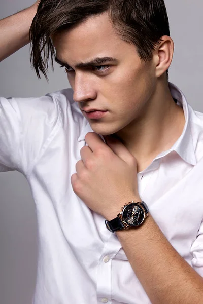 Ung man i vit skjorta bär klockor — Stockfoto