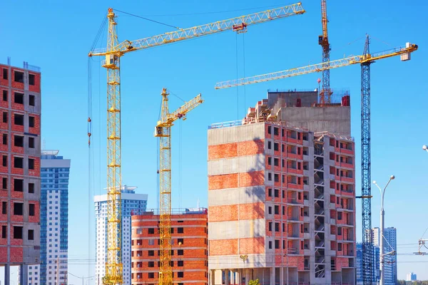 Bouwen met het hijsen van kranen, kranen op de bouw van het gebouw toren — Stockfoto