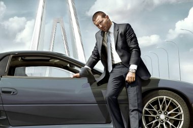 Arabanın yakınında duran ciddi iş adamı