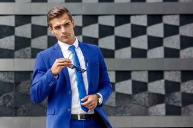 Bir arka plan koyu modern mimarinin mavi elbiseli bir adam