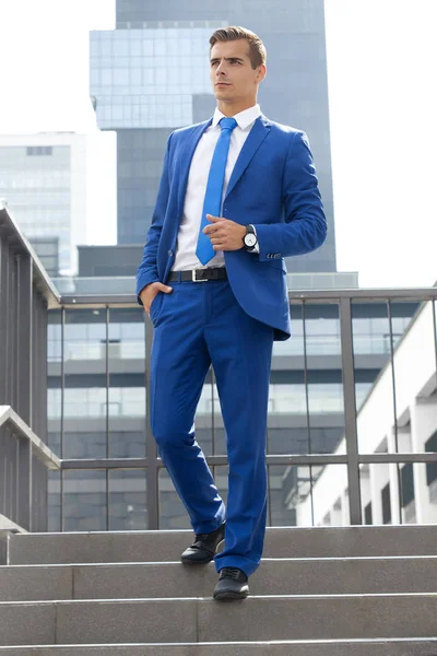 Elegáns férfi pózol egy modern épület a háttérben — Stock Fotó