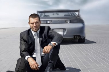 onun mavi arabanın yakınında oturan yakışıklı adam