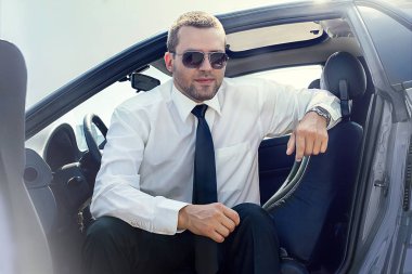 gri mavi arabada oturan yakışıklı adam