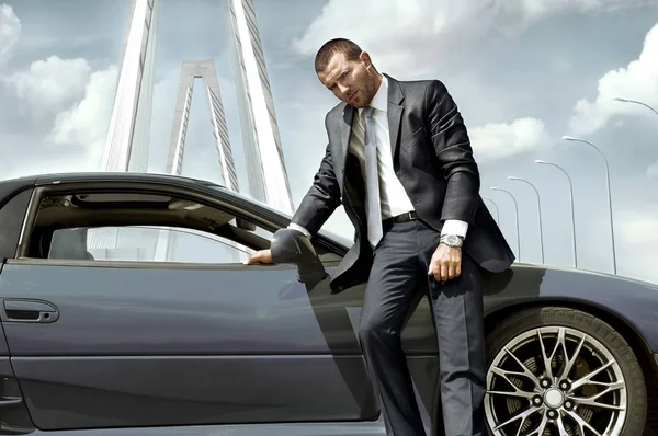 Arabanın yakınında duran ciddi iş adamı