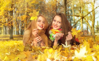 iki kız bir yaprak bir sonbahar Park yalan