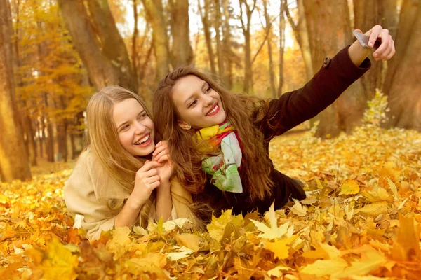 İki kız arkadaşım bir selphi bir yığın bir sonbahar Park yaprakların üzerinde yapıyoruz.