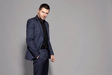 gri arka plan stüdyo üzerinde mavi elbiseli adam