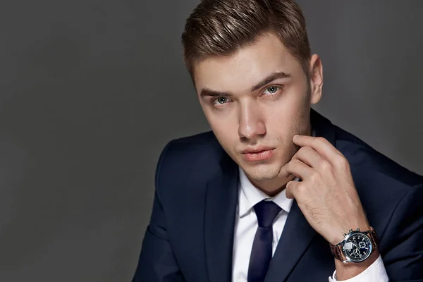 Retrato de un hombre sentado con un traje con un reloj, estudio —  Fotos de Stock