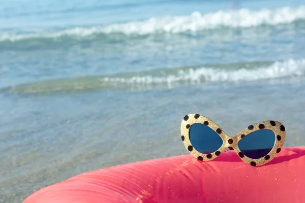 Okulary przeciwsłoneczne na tle morza surf — Zdjęcie stockowe