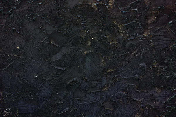Czarny stary mur, pęknięte betonowe tło, czarny dekoracyjny stiuk z odrobiną złota — Zdjęcie stockowe