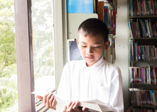 Asiático menino lendo um livro. — Fotografia de Stock