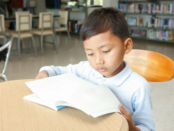 アジアの少年の図書館で本を読んで — ストック写真