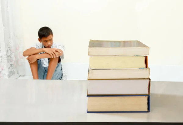 ストレスを持っている 代の少年とテーブルの上の多くの教科書 — ストック写真