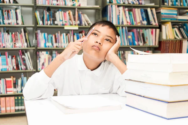 図書館で宿題をしているアジアの少年 — ストック写真