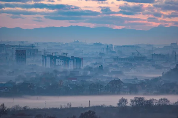 Sunset in the evening over the city in the fog — ストック写真