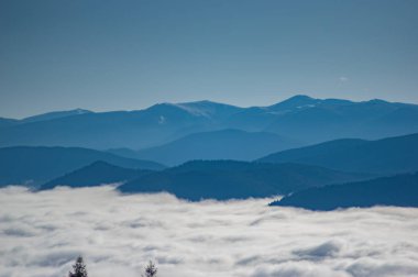 Dağların yükseklerinden ve sisle kaplı ormanlardan manzara.