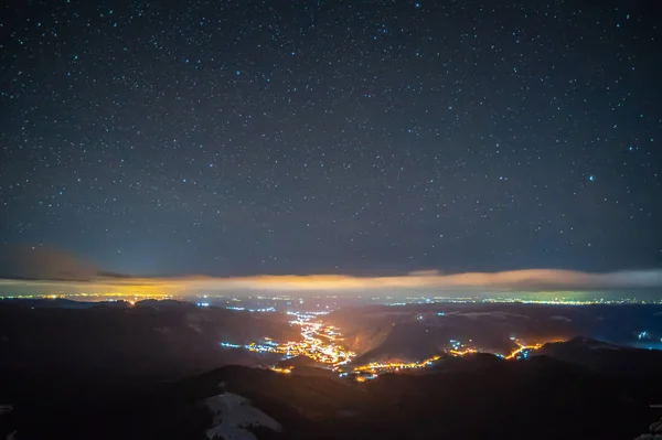 Ciudad nocturna en la niebla en las montañas en otoño —  Fotos de Stock