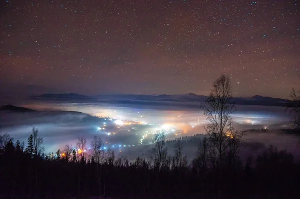 Nachtstadt im Nebel in den Bergen im Herbst — Stockfoto