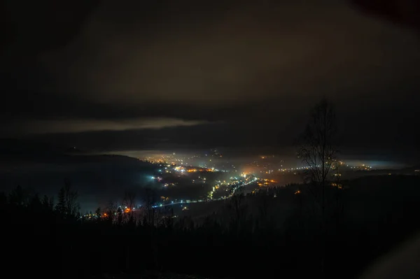 Ciudad nocturna en la niebla en las montañas en otoño — Foto de Stock