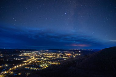 Gece şehrinin üzerinde yıldızlı gökyüzü