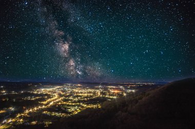Gece şehrinin üzerinde yıldızlı gökyüzü