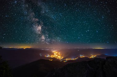 Gece şehrinin üzerinde yıldızlı gökyüzü