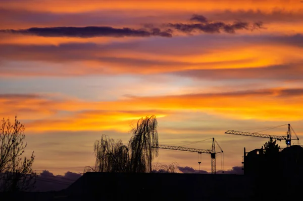 夕阳西下的天空笼罩着这座城市的房屋 — 图库照片