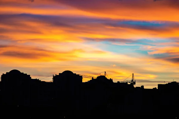 Färgglad solnedgång himmel över husen i staden — Stockfoto
