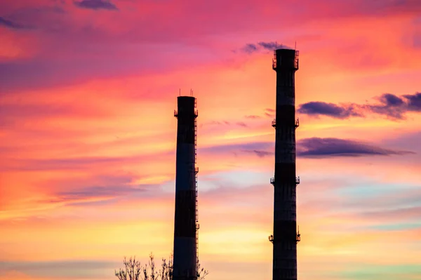 Rör av ett kraftverk mot solnedgången himlen — Stockfoto