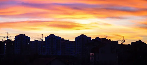 Panorama de céu colorido por do sol sobre as silhuetas das casas — Fotografia de Stock