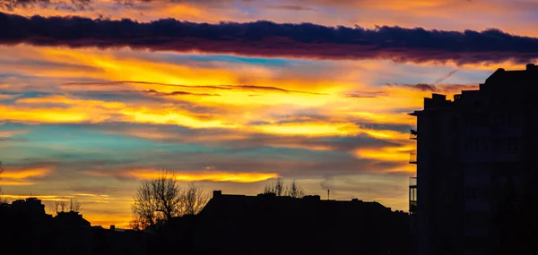 Panorama des farbenfrohen Sonnenuntergangs über den Silhouetten der Häuser — Stockfoto