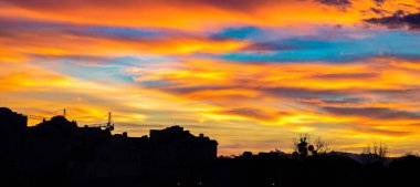Renkli günbatımı manzarası ev siluetleri üzerinde gökyüzü