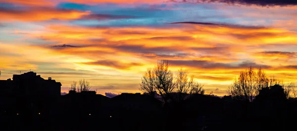 Panorama av färgglada solnedgång himlen över silhuetter av hus — Stockfoto