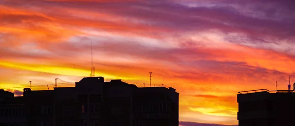 住宅のシルエットの上にカラフルな夕日の空のパノラマ — ストック写真