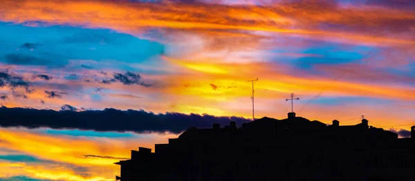 Panorama de céu colorido por do sol sobre as silhuetas das casas — Fotografia de Stock