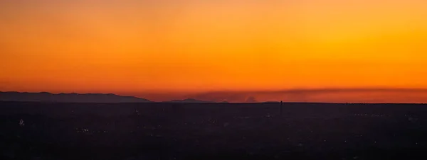 Baharda şehrin arka planında gün batımı — Stok fotoğraf