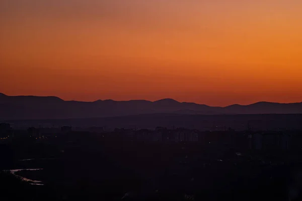 Solnedgång på bakgrunden av staden på våren — Stockfoto