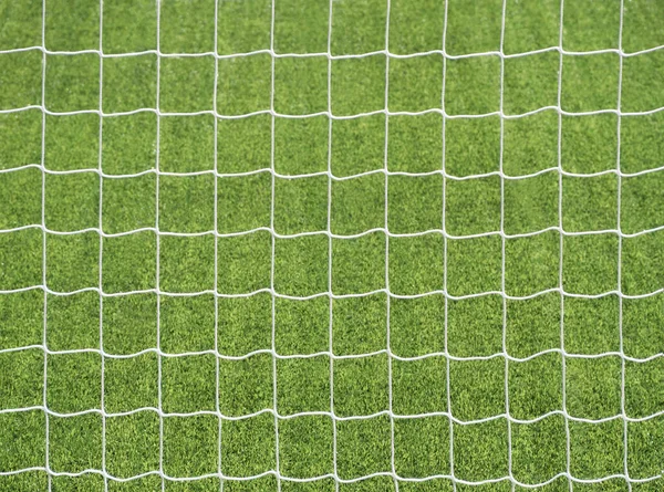 Closeup of goal post net at green football field background. Abstract pattern of sport equipment